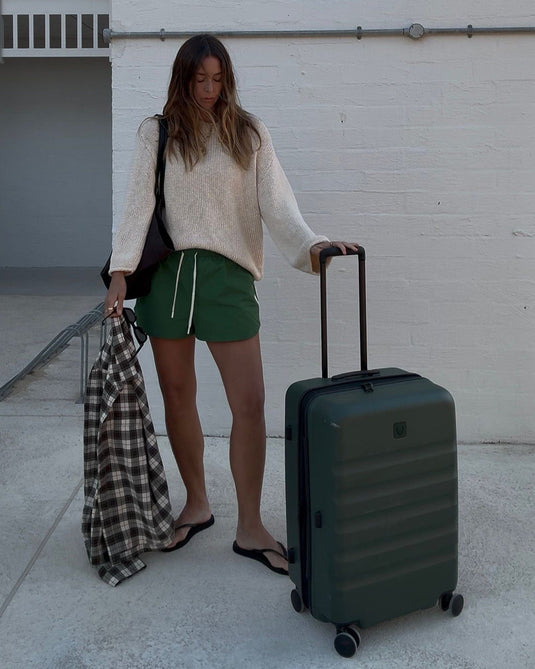 a woman standing next to a suitcase