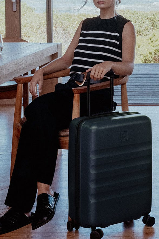 a woman sitting in a chair with a suitcase