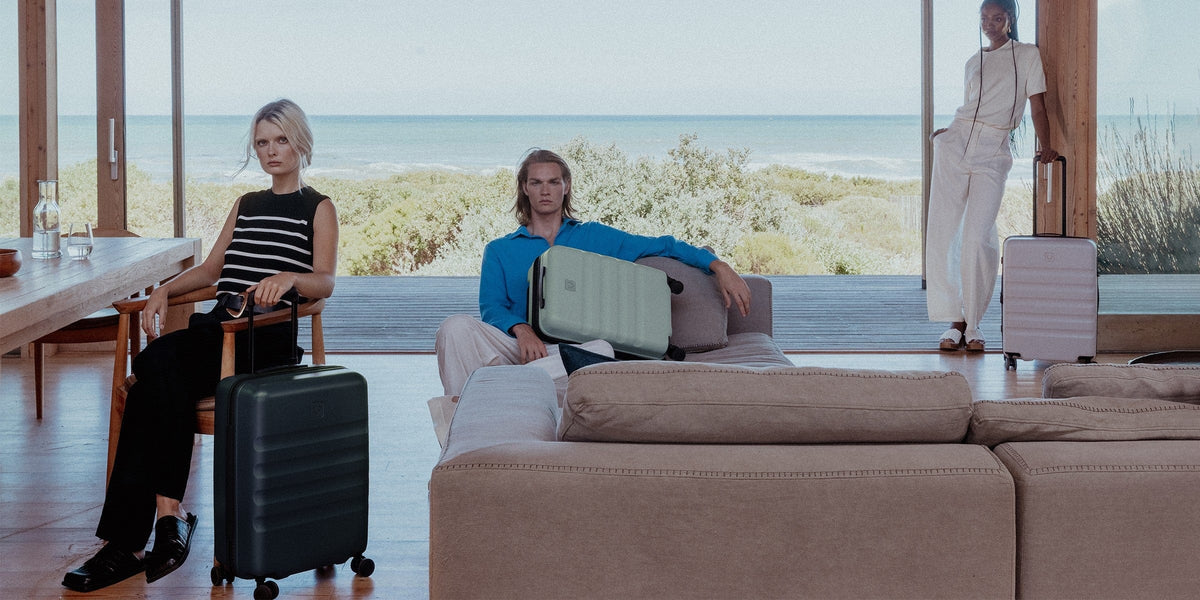 a man and woman sitting on a couch with luggage