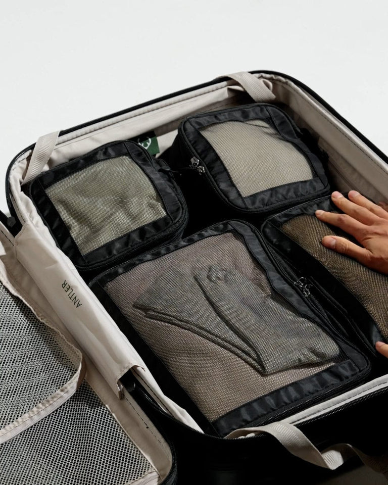 a hand putting a luggage bag into it
