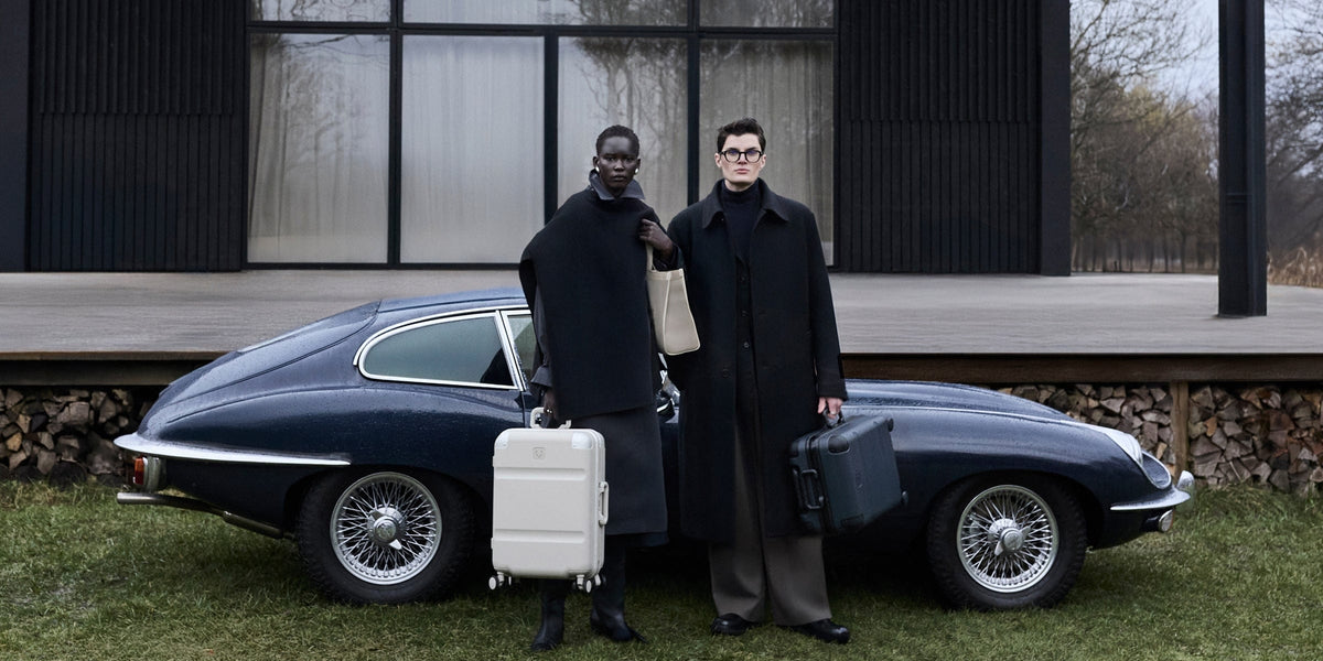 a couple of people standing in front of a car