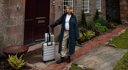 a woman standing outside a building with luggage