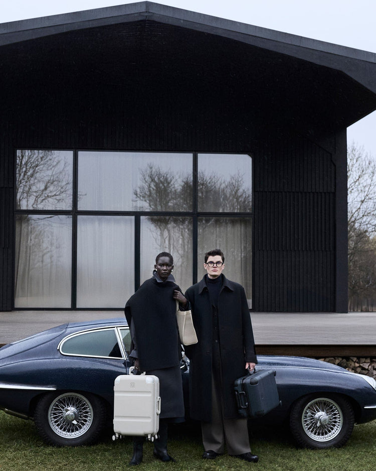 a couple of people standing in front of a car