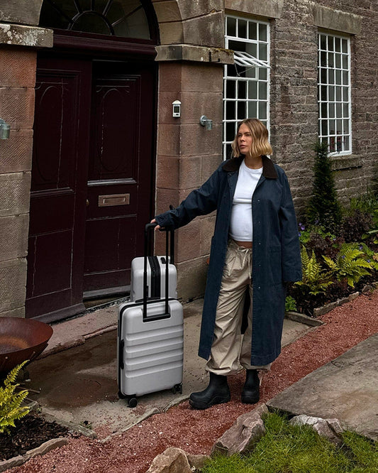 a woman standing outside a building with luggage