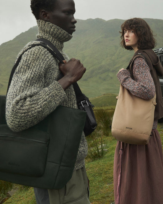 a man and woman standing in a grassy area