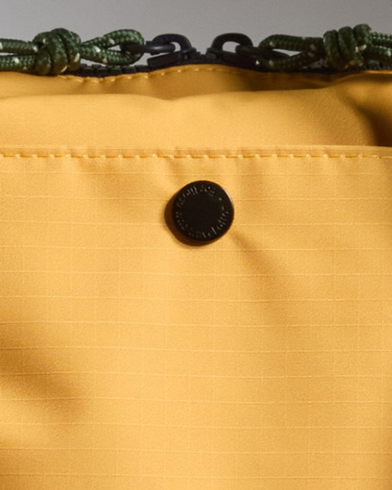 a close up of a button on a yellow bag