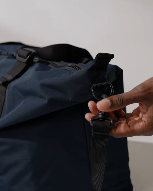 a hand holding a strap to a bag