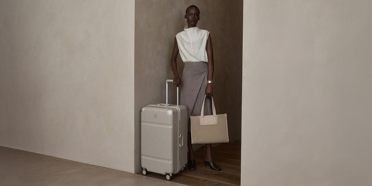 a woman holding a bag and a suitcase