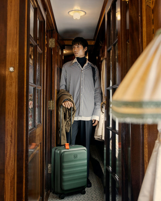 a man standing in a hallway with a suitcase