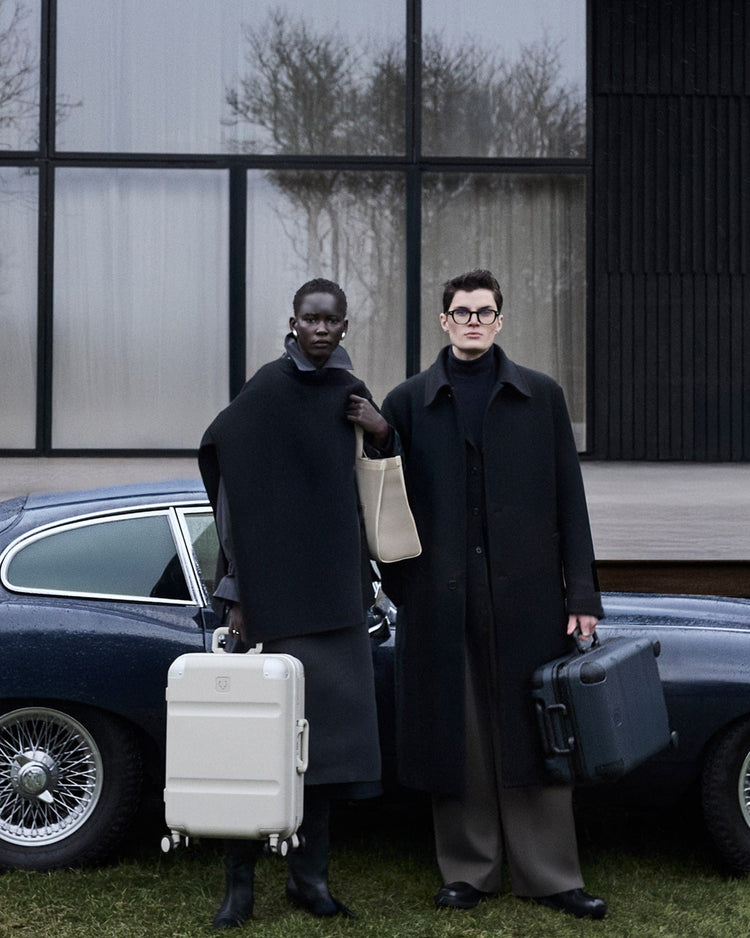 a couple of people standing in front of a car