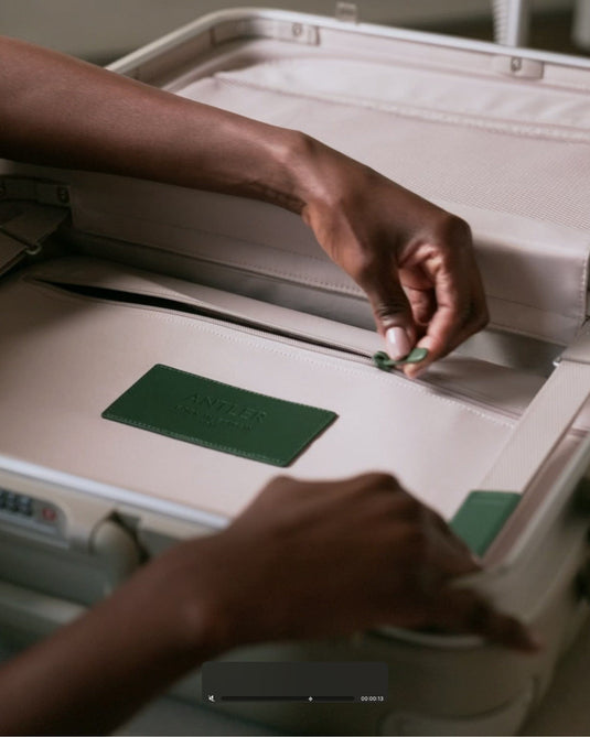 a person putting a green tag in a suitcase