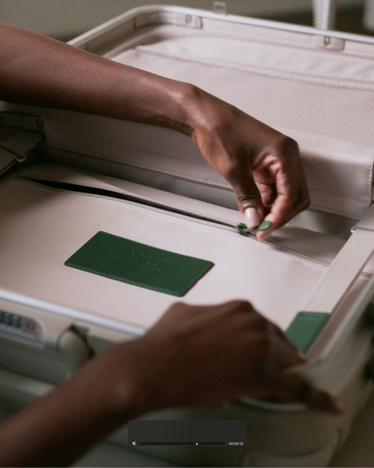 a person putting a green tag in a suitcase