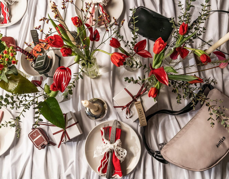 a table with flowers and plates and a purse