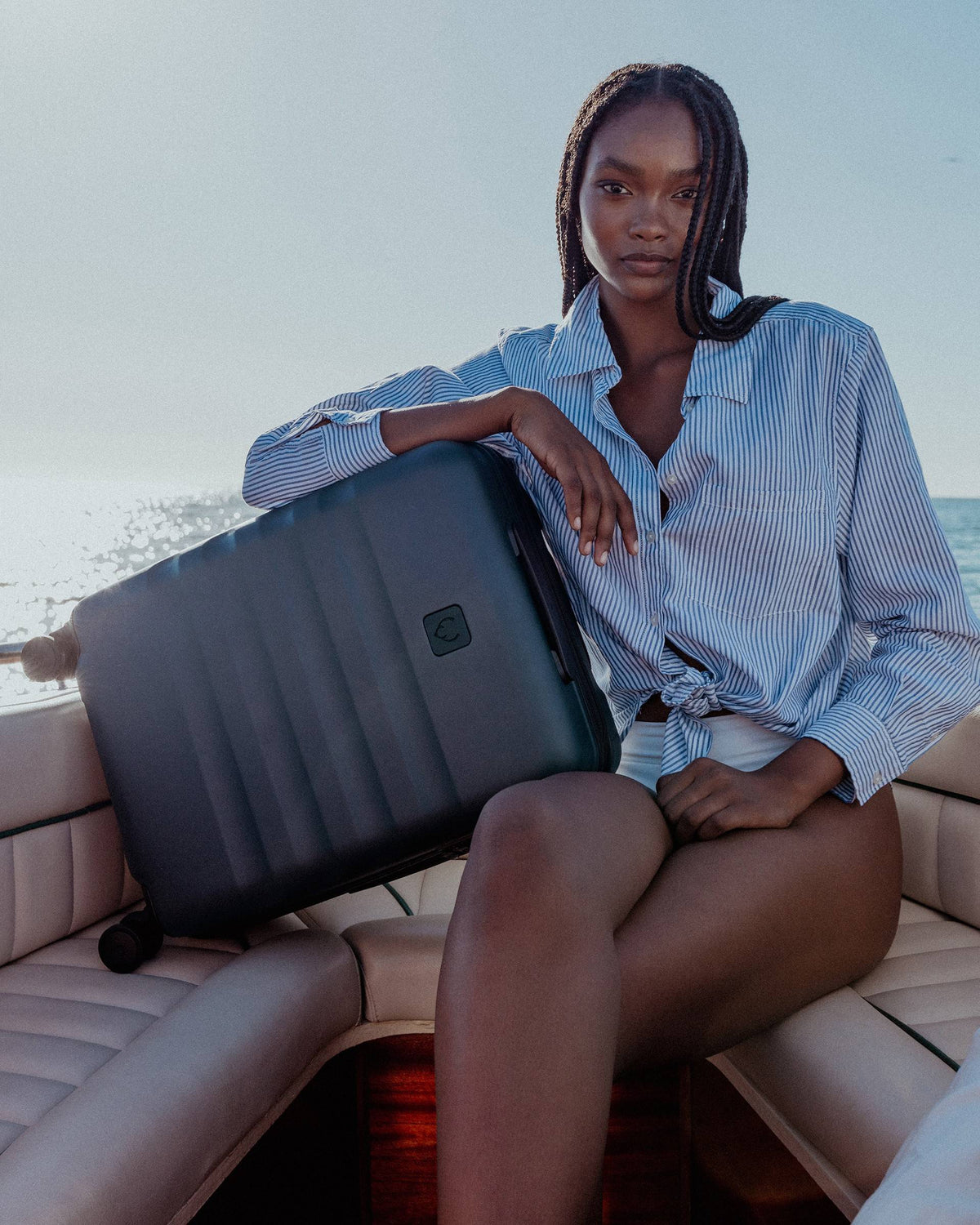 a woman sitting on a boat with a suitcase