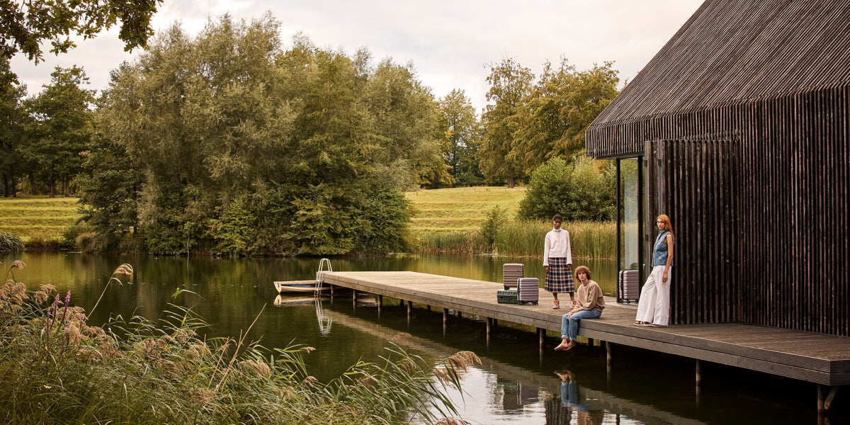 a man and woman sitting on a dock near a lake