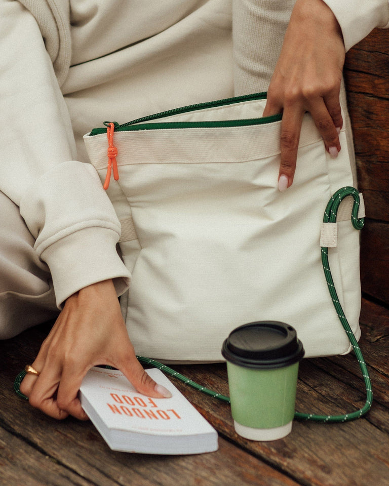 a person holding a bag and a cup of coffee