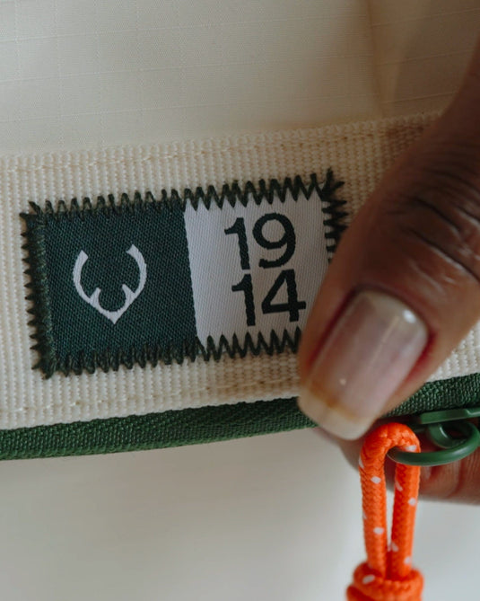 a hand holding a tag with numbers and a string