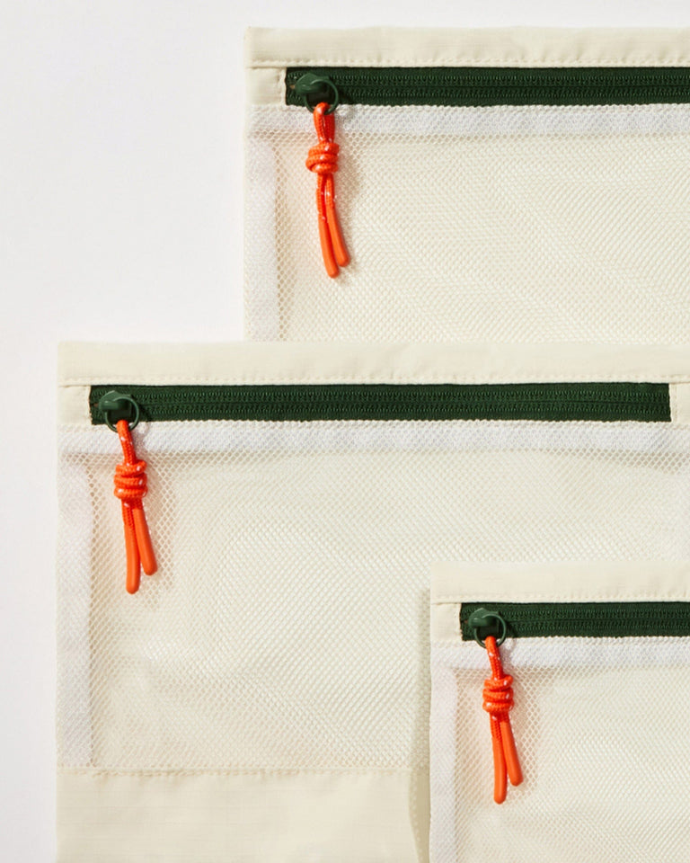a group of white bags with orange zippers