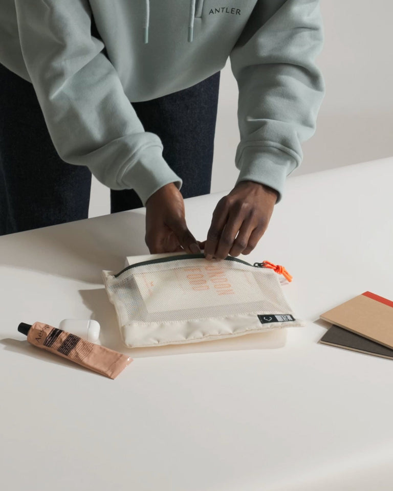 a person opening a small white bag