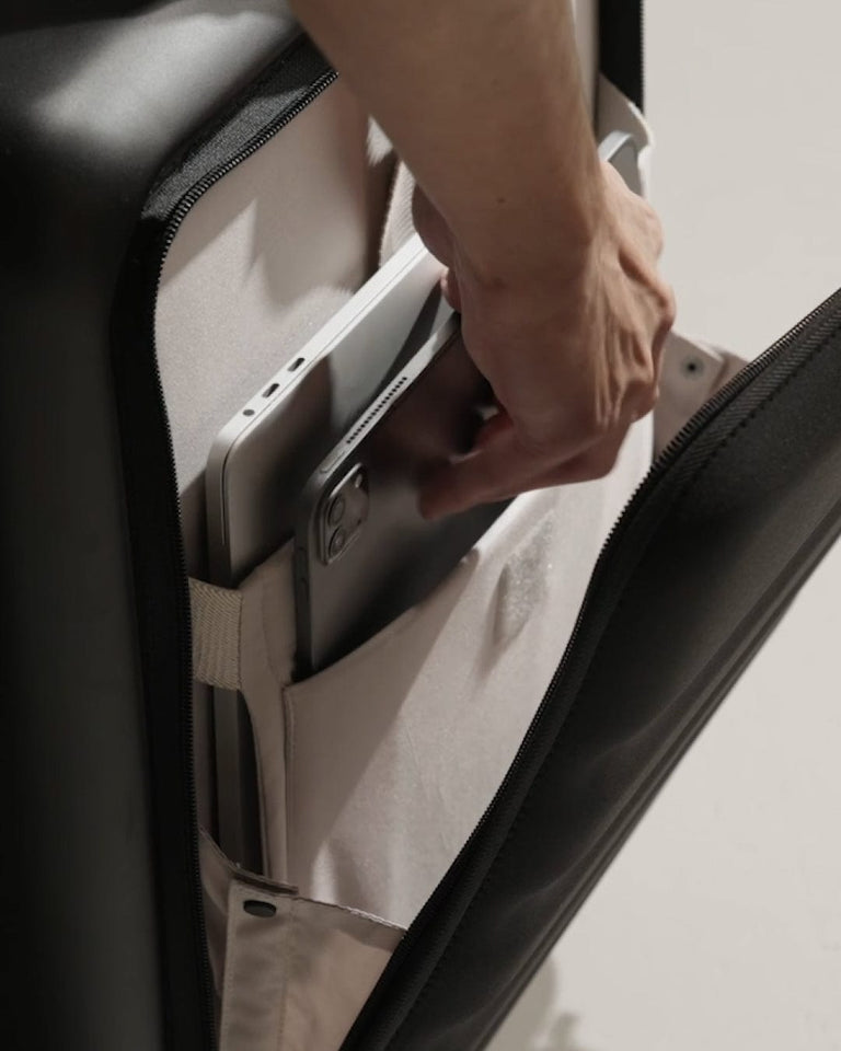 a hand holding a phone in a suitcase