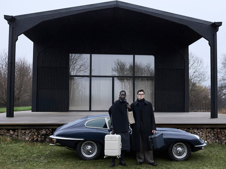 a couple of people standing in front of a car