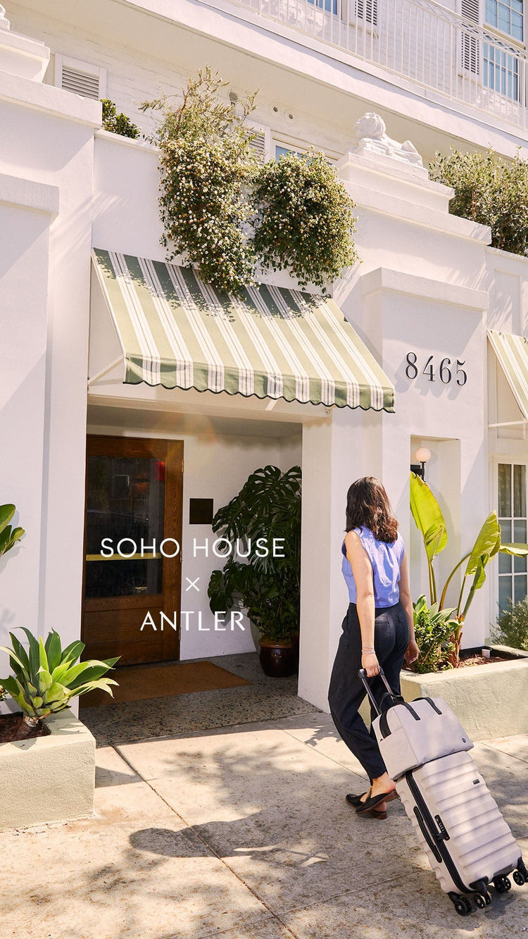 a woman with luggage in front of a building