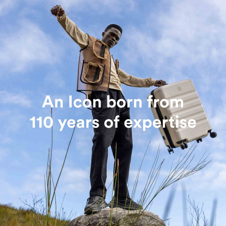 a man standing on a rock holding a suitcase