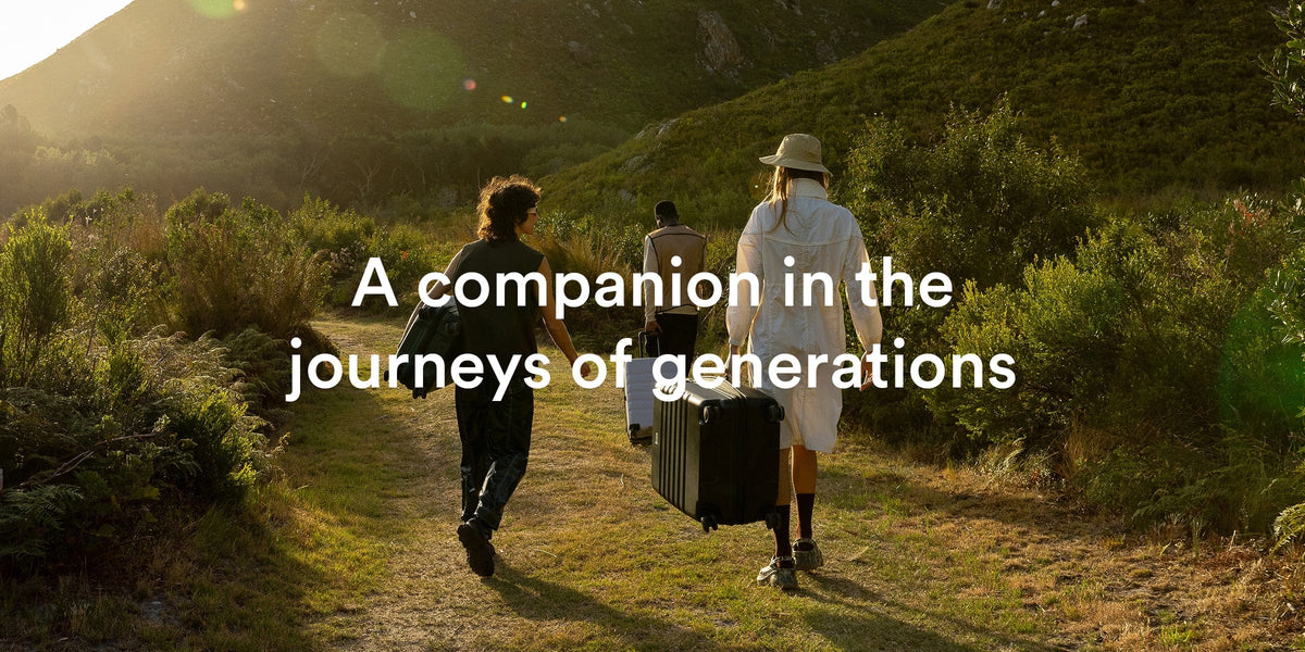 a group of people walking on a path with luggage