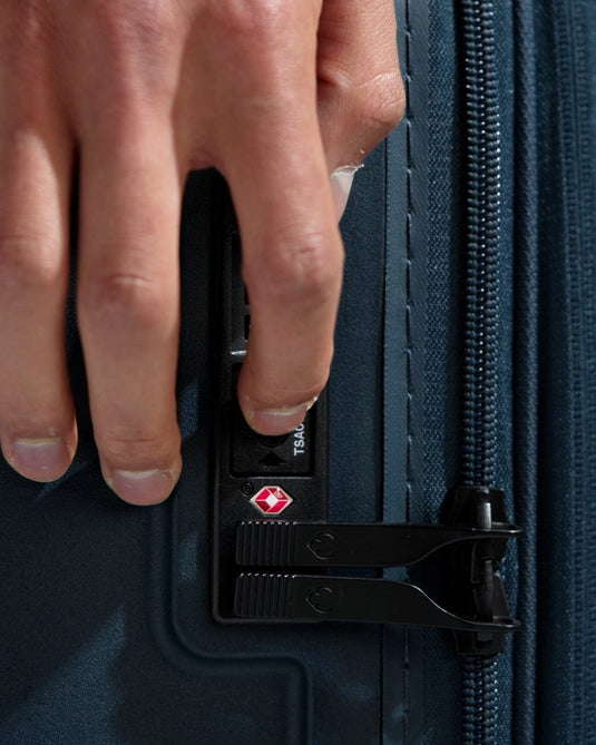 a hand opening a zipper on a suitcase