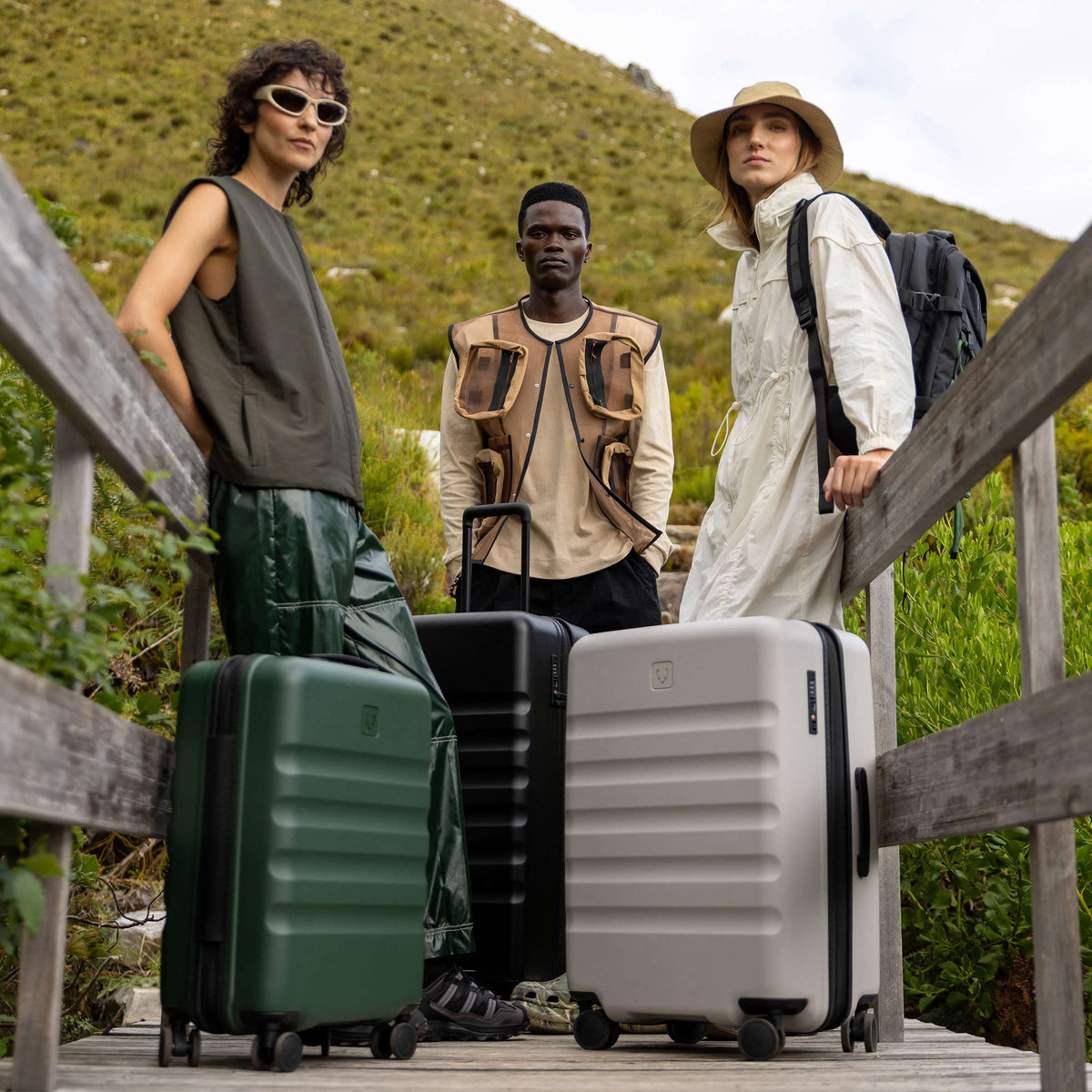 a group of people standing on a bridge with luggage