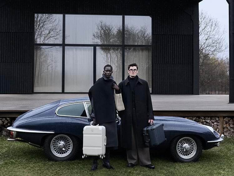 two people standing in front of a car