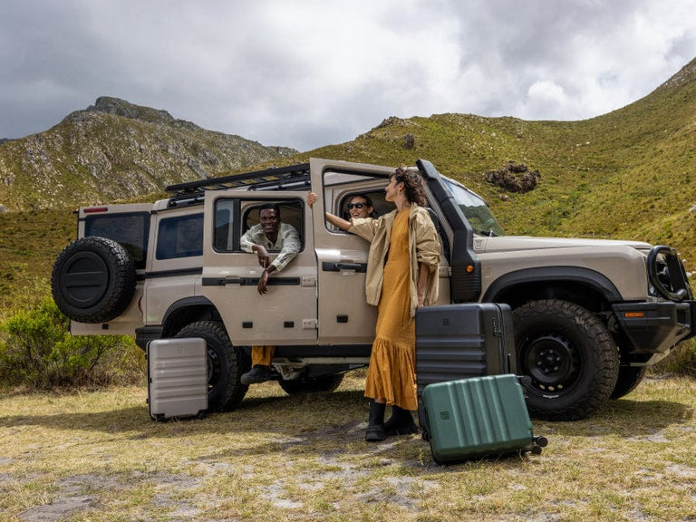 a group of people standing in a car with luggage