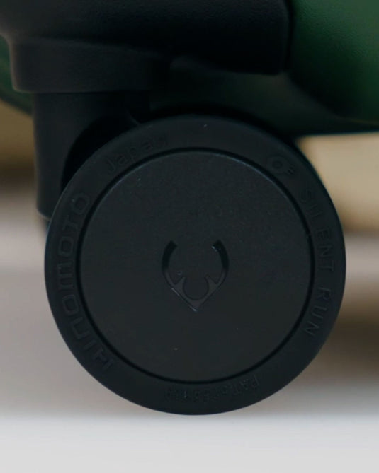 a black wheel on a green and black suitcase