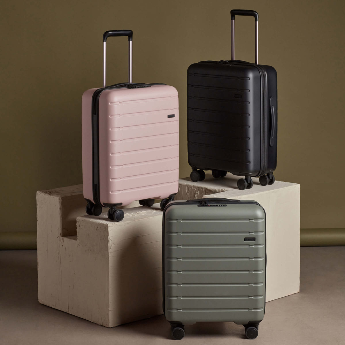 a group of luggage on a white block