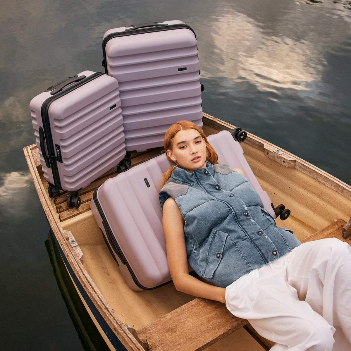 a woman lying in a boat with luggage