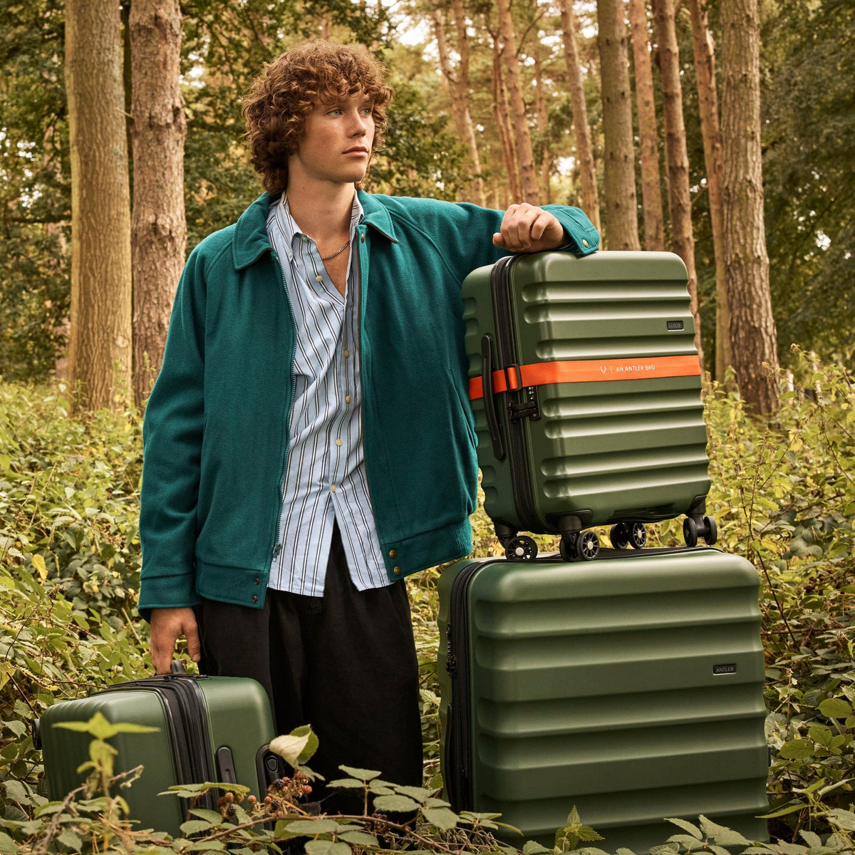 a man standing next to a stack of luggage